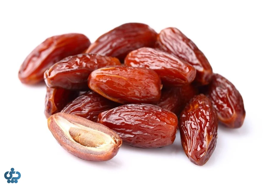 خرمای رسیده تازه به همراه هسته خرما روی پس‌زمینه سفید