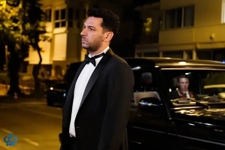 شخصیت مرد سریال گلها و گناهان با لباس رسمی کنار خودرو در شب
